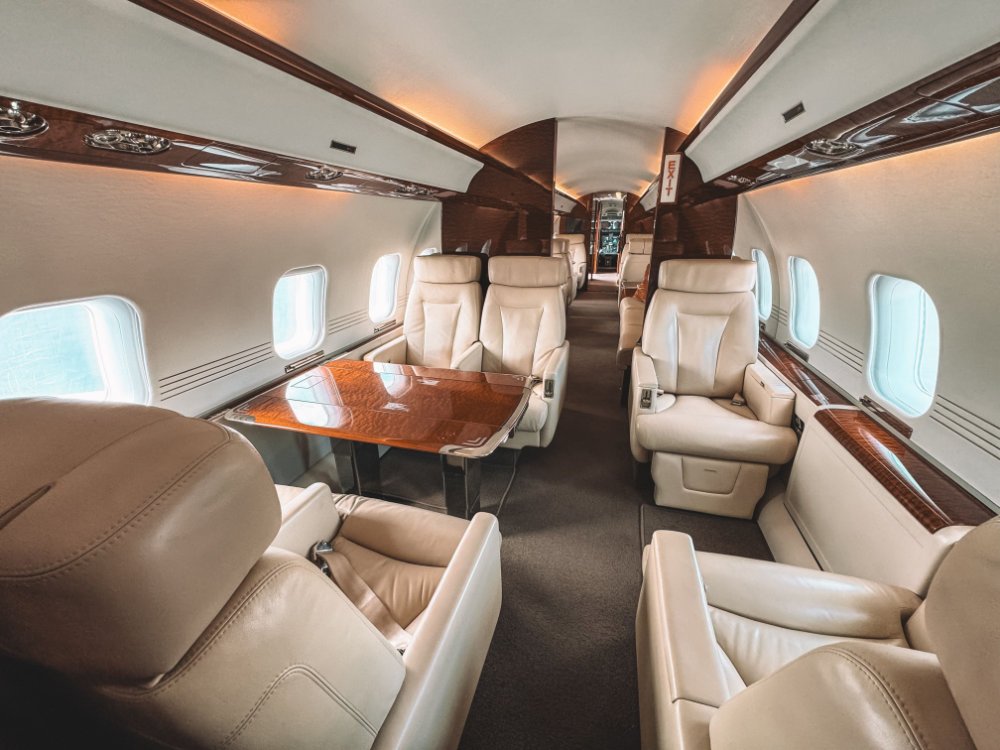 Luxury private jet interior with leather seats and wood trim